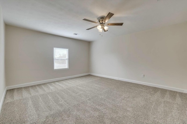 unfurnished room with ceiling fan and carpet