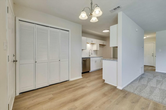 kitchen featuring sink, stainless steel dishwasher, a notable chandelier, decorative light fixtures, and white cabinets