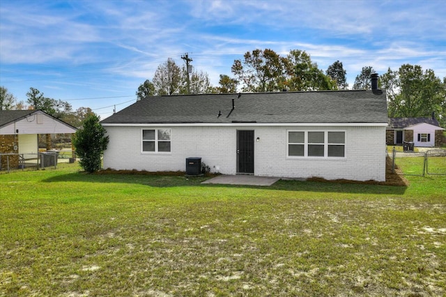 rear view of property featuring a yard, central AC, and a patio area