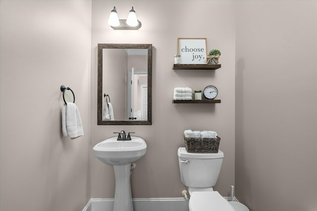 bathroom featuring toilet and baseboards