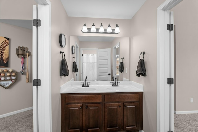 bathroom with double vanity, a sink, and baseboards