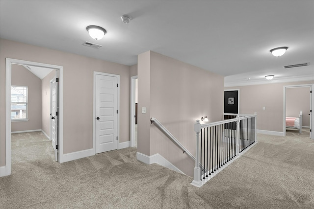 hall with visible vents, carpet flooring, an upstairs landing, and baseboards