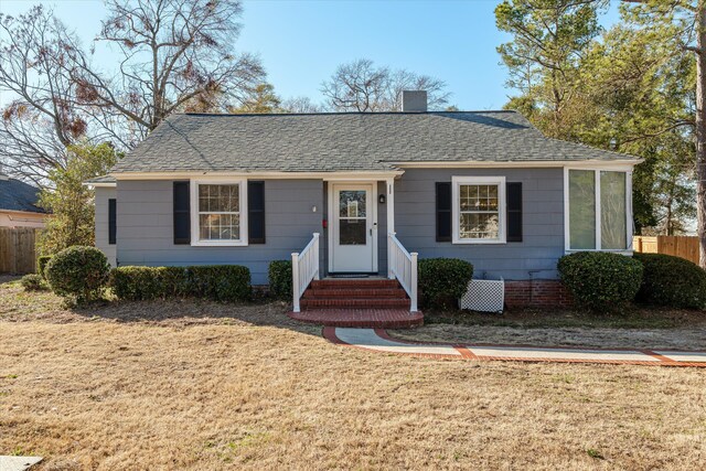 view of front of house featuring cooling unit and a front lawn