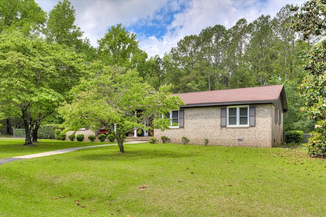 view of front facade with crawl space, brick siding, and a front yard
