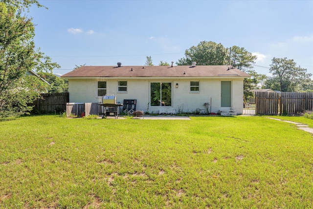 back of house with a yard and a patio