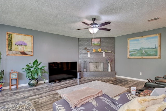 2382 Patrick Ave, Hephzibah, GA 30815 - living room with wood finished floors, a ceiling fan, baseboards, a textured ceiling, and a fireplace