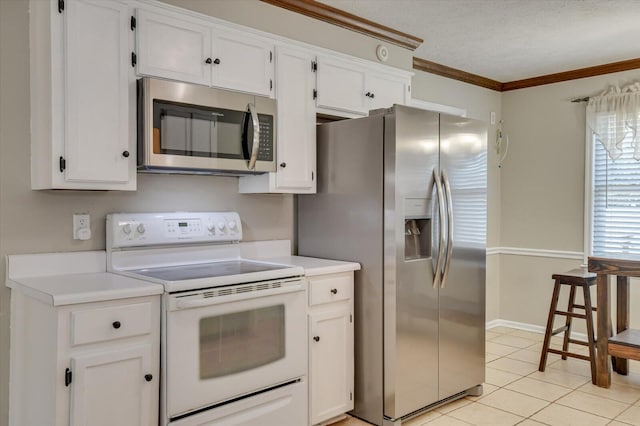 kitchen with crown molding, light countertops, light tile patterned floors, appliances with stainless steel finishes, and white cabinets