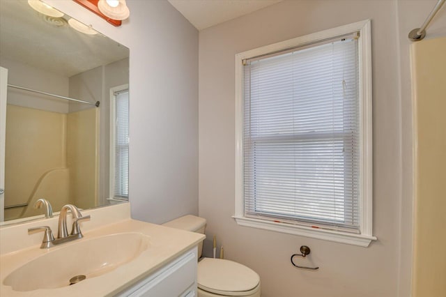 bathroom featuring vanity, toilet, and a shower