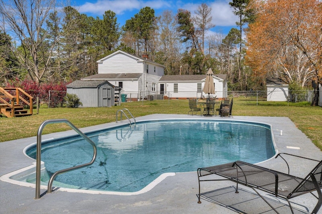 view of swimming pool with a fenced in pool, fence, an outdoor structure, a yard, and a storage unit