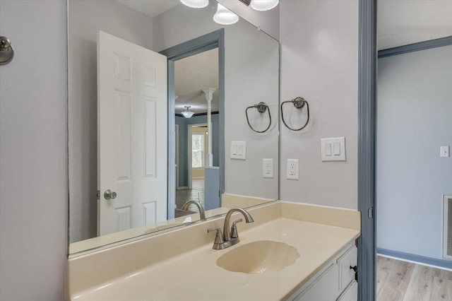 bathroom with wood finished floors and vanity