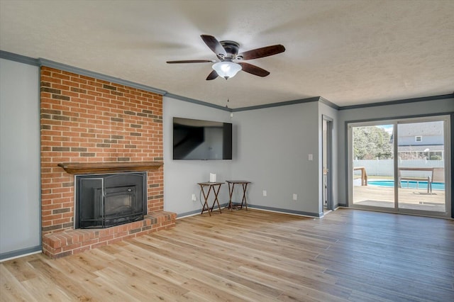 unfurnished living room featuring a ceiling fan, wood finished floors, crown molding, and a textured ceiling