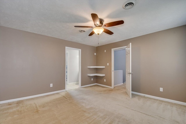spare room with a ceiling fan, baseboards, visible vents, a textured ceiling, and carpet flooring
