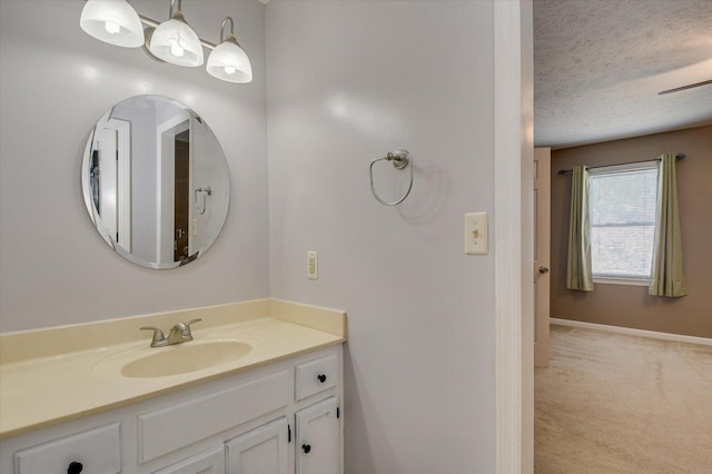bathroom with vanity, baseboards, and a textured ceiling