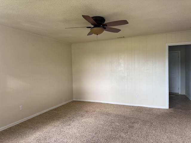 carpeted spare room featuring ceiling fan, baseboards, a textured ceiling, and visible vents