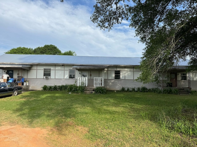 ranch-style home featuring a front lawn and metal roof