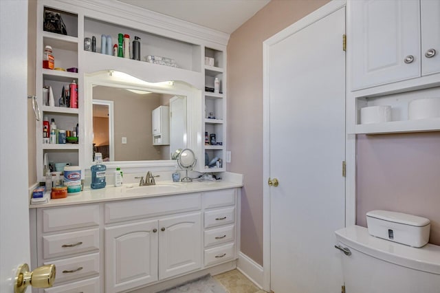 bathroom with toilet, vanity, and tile patterned flooring