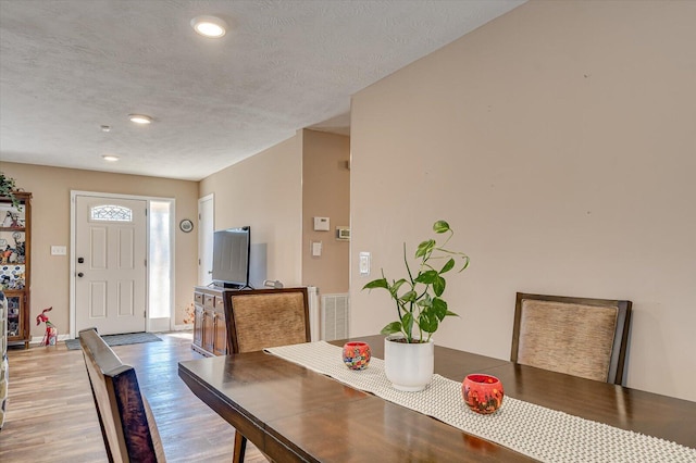 dining area with a textured ceiling and hardwood / wood-style flooring