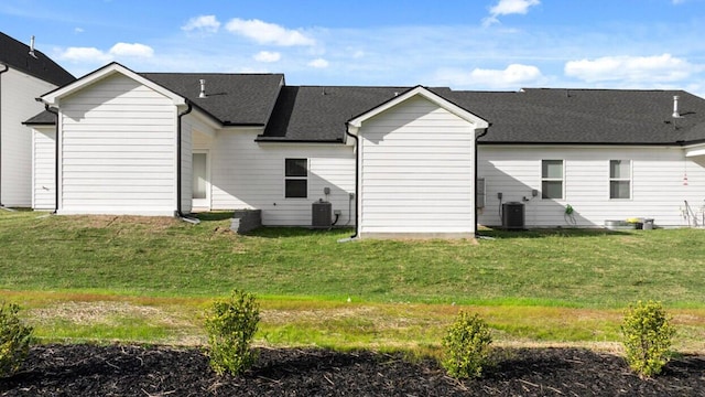 rear view of property with a yard and central AC unit