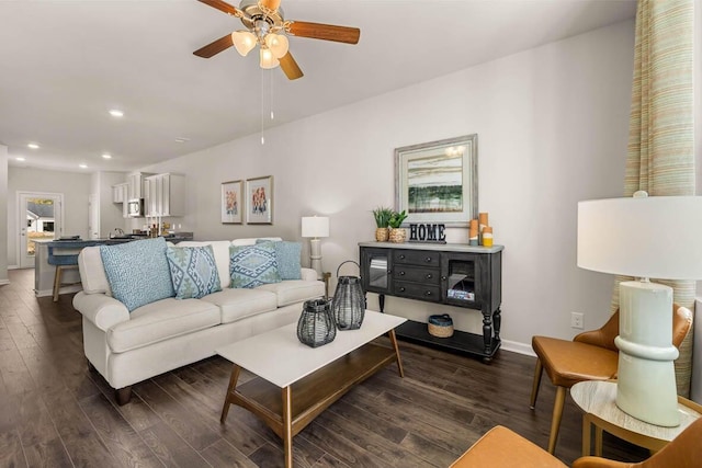 living room with ceiling fan and dark hardwood / wood-style flooring