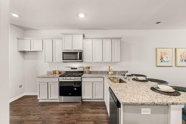 kitchen with stainless steel appliances, white cabinets, sink, and light stone countertops