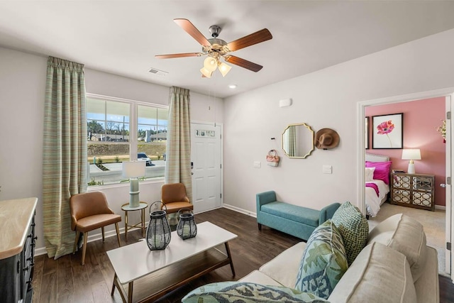 living room featuring ceiling fan and dark hardwood / wood-style floors