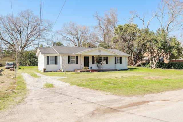 view of front of house with covered porch, dirt driveway, and a front lawn