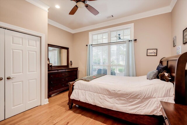 bedroom with ceiling fan, light hardwood / wood-style floors, crown molding, and a closet