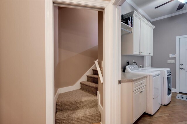 washroom featuring cabinets, crown molding, washer and dryer, ceiling fan, and wood-type flooring