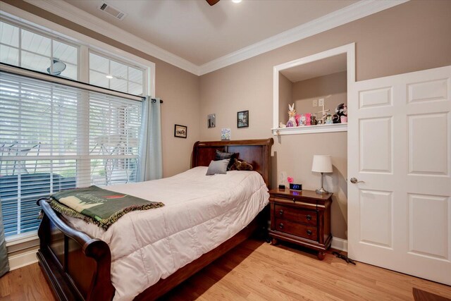 bedroom featuring ceiling fan, crown molding, and hardwood / wood-style flooring