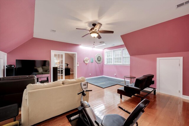 exercise area with ceiling fan, light hardwood / wood-style flooring, and lofted ceiling