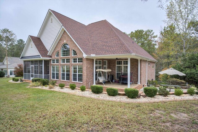 rear view of house with a sunroom and a yard