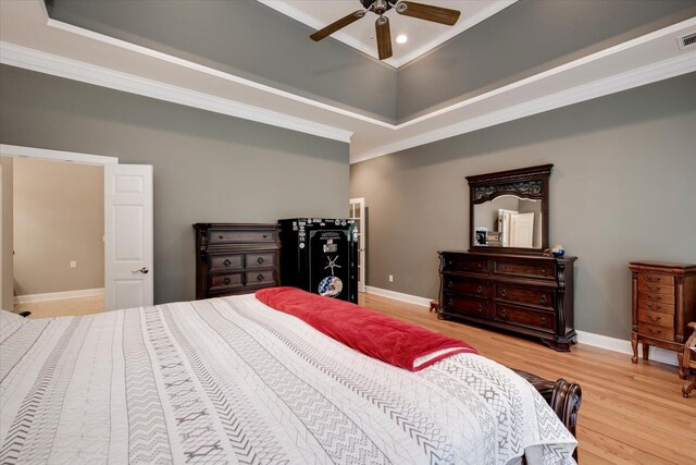 bedroom with ceiling fan, a raised ceiling, and crown molding