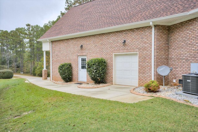 view of property exterior featuring a yard, central AC unit, and a garage