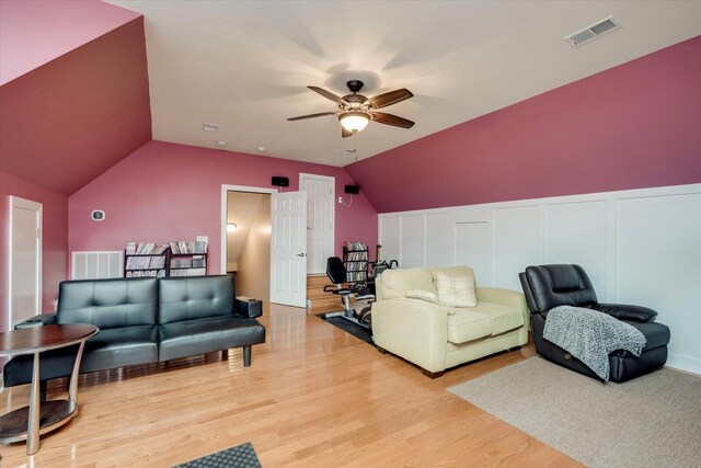 living room with hardwood / wood-style floors, ceiling fan, and lofted ceiling