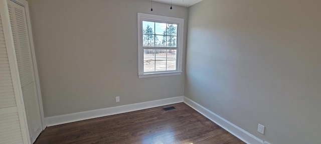 empty room with dark hardwood / wood-style flooring