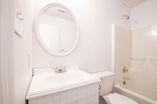 full bathroom with vanity, shower / bath combination, and toilet