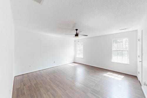 spare room with hardwood / wood-style flooring and ceiling fan