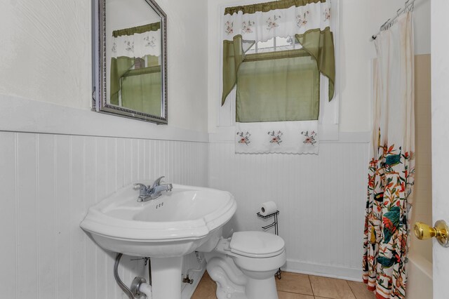 bathroom with tile patterned flooring, toilet, and shower / tub combo with curtain