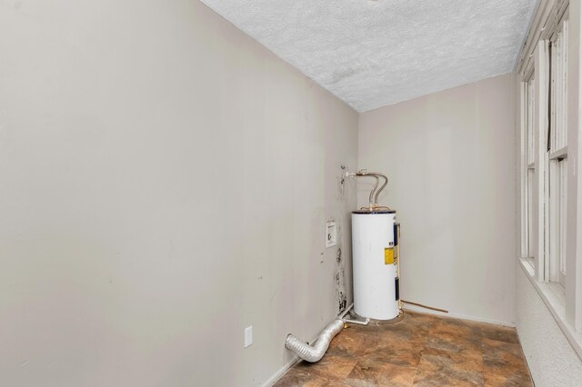 laundry room featuring a textured ceiling and water heater