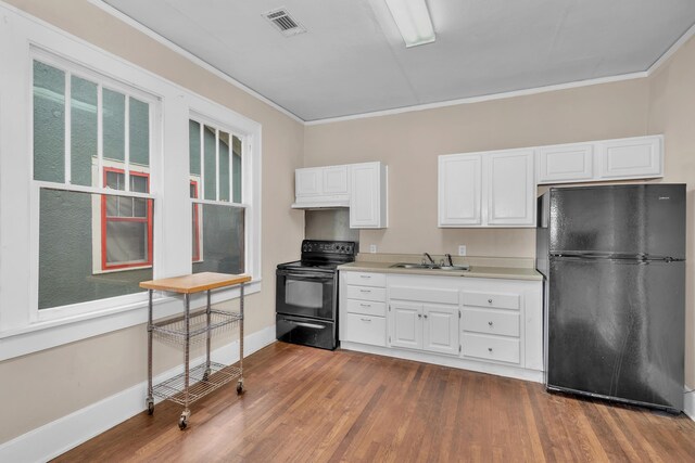 kitchen with sink, dark hardwood / wood-style floors, crown molding, white cabinets, and black appliances