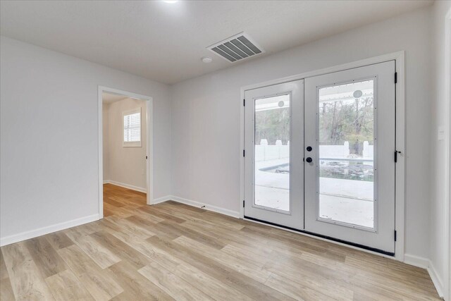 doorway with light wood-style flooring, plenty of natural light, french doors, and visible vents