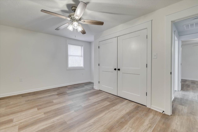 unfurnished bedroom with visible vents, a ceiling fan, a closet, light wood-style floors, and baseboards