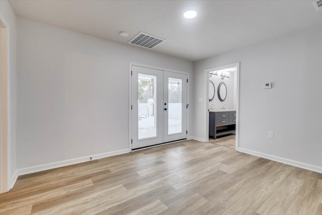 unfurnished room featuring visible vents, baseboards, light wood-style flooring, and french doors