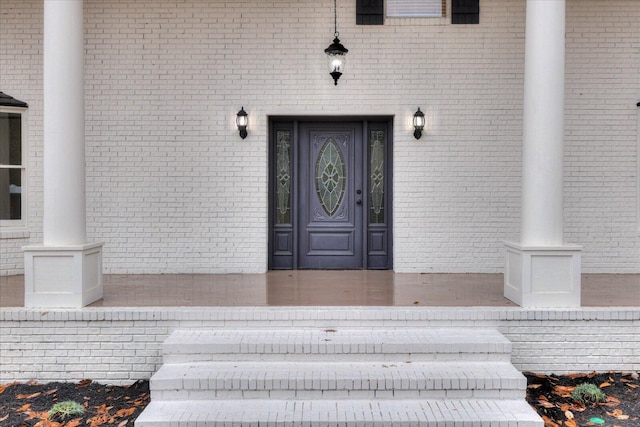 doorway to property featuring brick siding