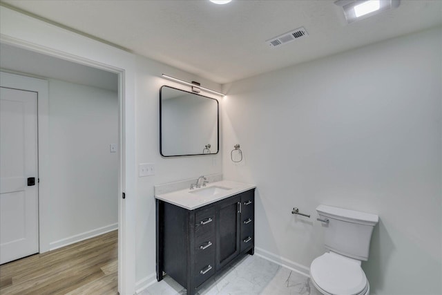 bathroom featuring vanity, baseboards, visible vents, toilet, and marble finish floor