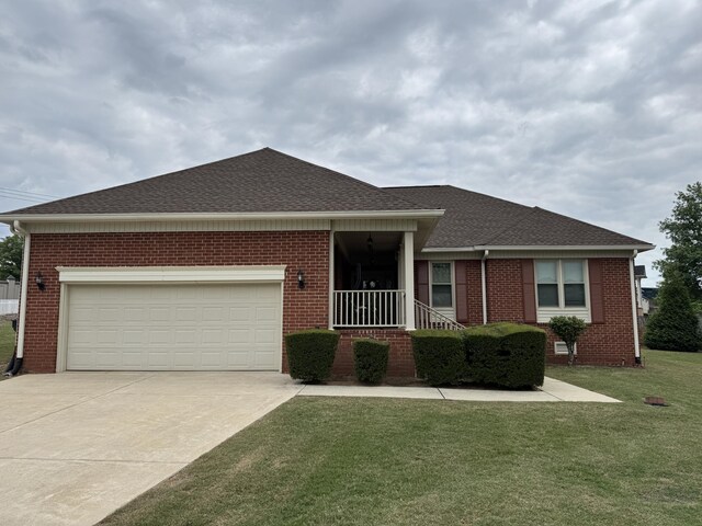 view of front of home with roof with shingles, a front yard, driveway, and brick siding