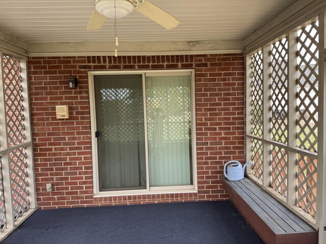 unfurnished sunroom featuring ceiling fan