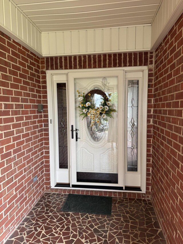 property entrance featuring brick siding