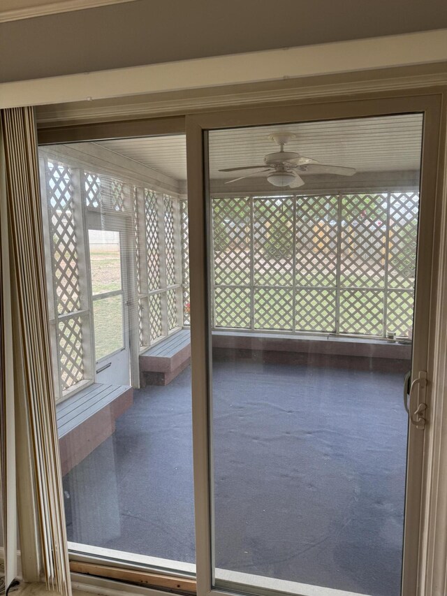 unfurnished sunroom with a ceiling fan