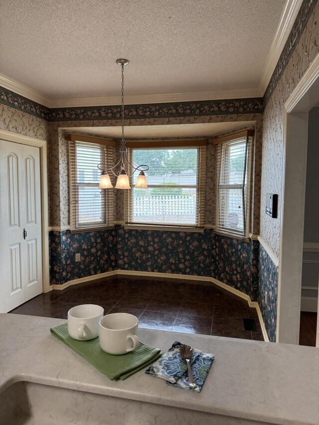 tiled dining area featuring ornamental molding, a textured ceiling, and wallpapered walls